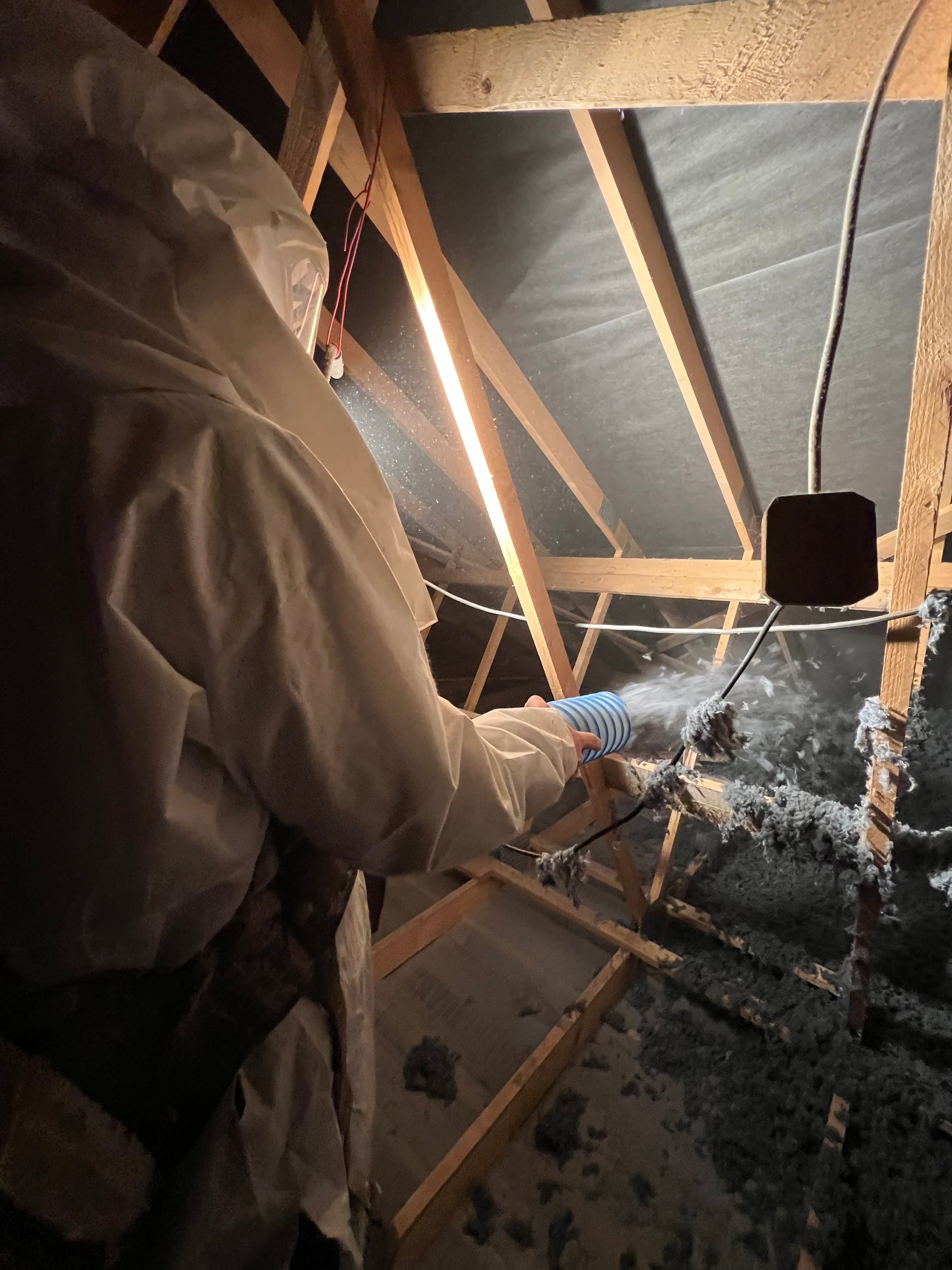 Applicateur Isolatech en plein soufflage de ouate de cellulose dans des combles · isolation thermique sous charpente bois · Saint-Barthélemy (Haute-Saône) · Isolatech