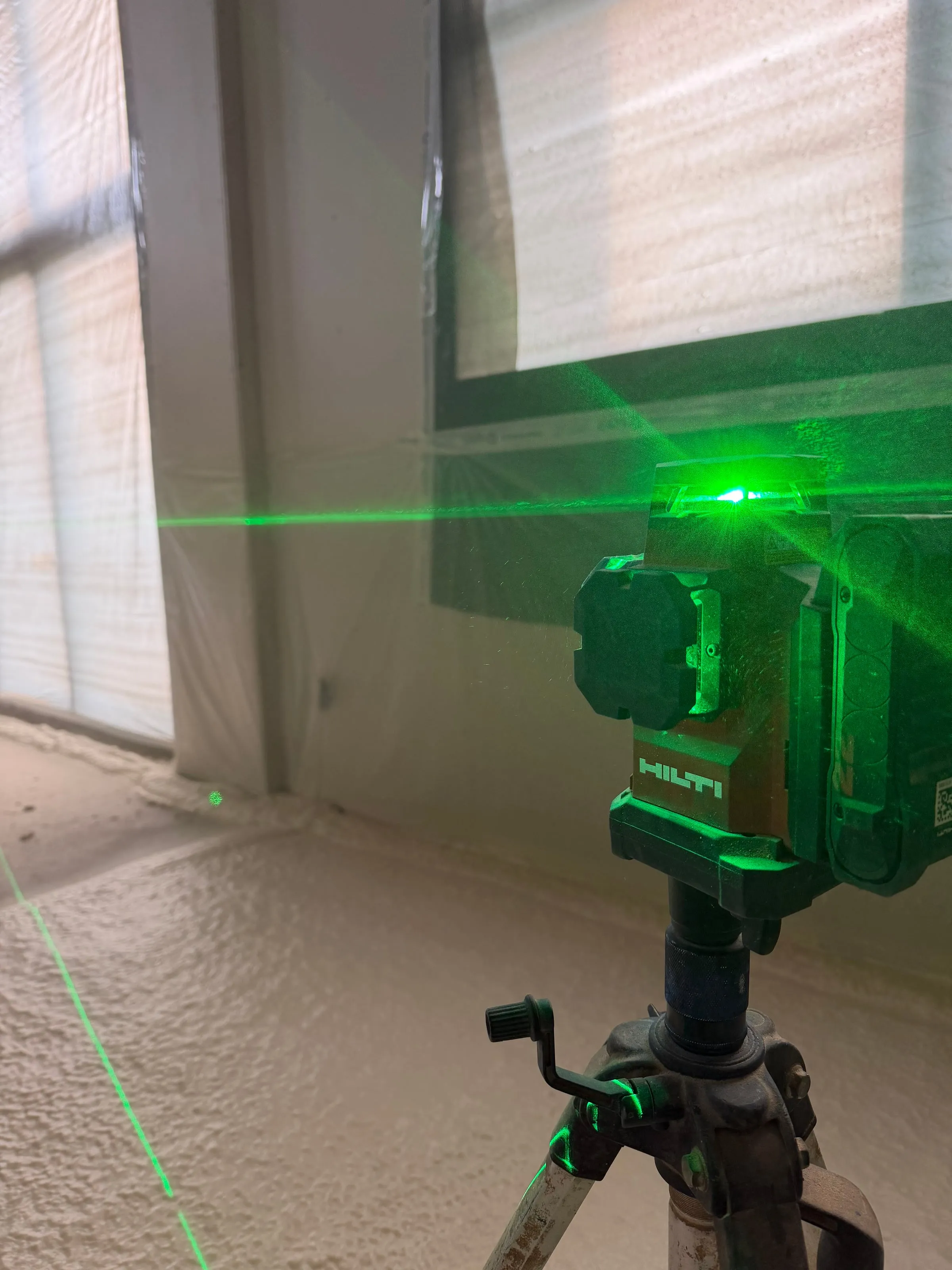 Niveau laser Hilti en repérage avant projection polyuréthane