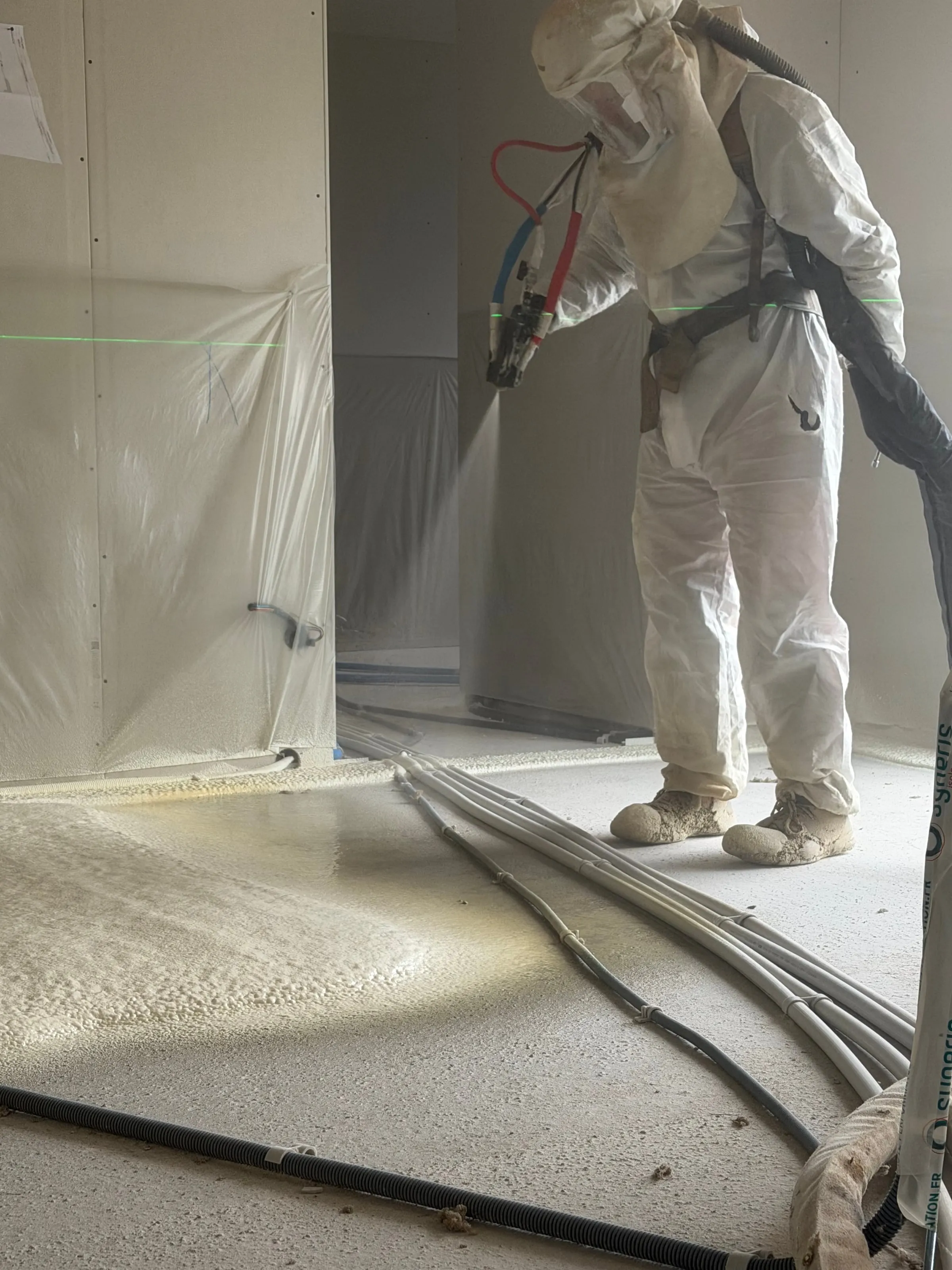 Projection polyuréthane sur sol, vue rapprochée mousse jaune · Isolatech